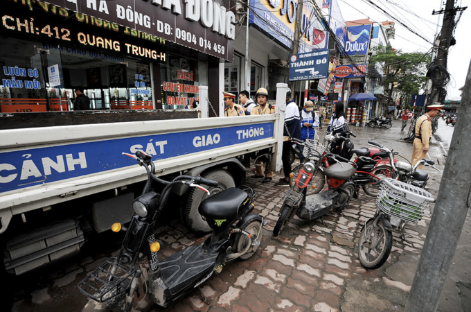 Cảnh sát giao thông Hà Nội xử phạt học sinh đi xe máy, xe đạp điện không đội mũ bảo hiểm. Ảnh: Giang Huy